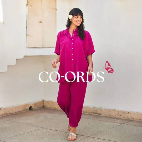 A woman in a vibrant, patterned co-ord set standing in a garden.